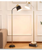Slim Brass Torchiere Floor Lamp with Tilted Cone Shade and Adjustable Neck | Thrascher